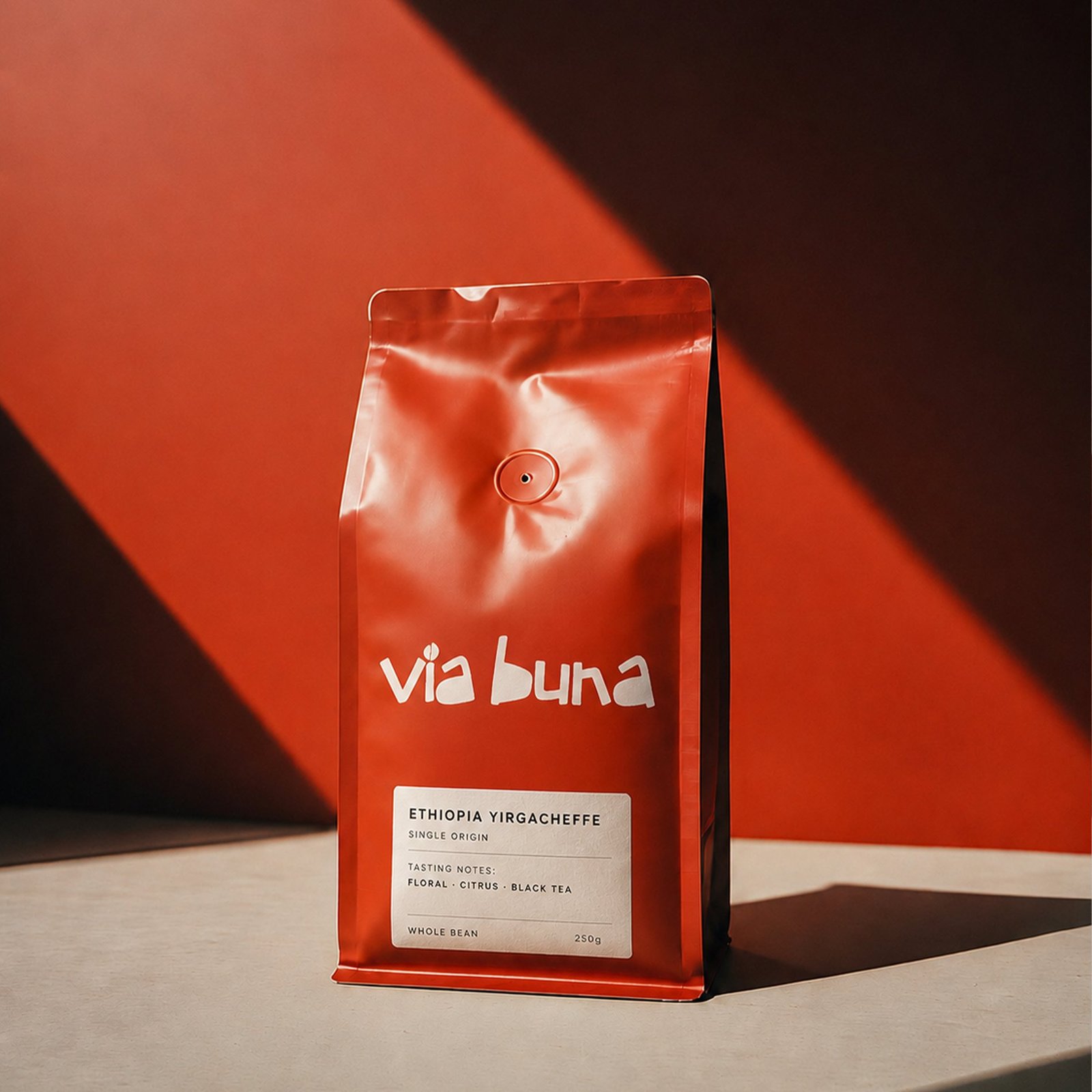 Via Buna Ethiopia Yirgacheffe whole bean bag, styled against a rust-orange backdrop